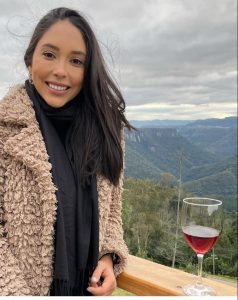 Mulher tomando um vinho com montanhas ao fundo