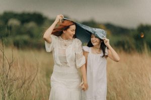 uma mãe e uma filha numa planice com um vestido branco